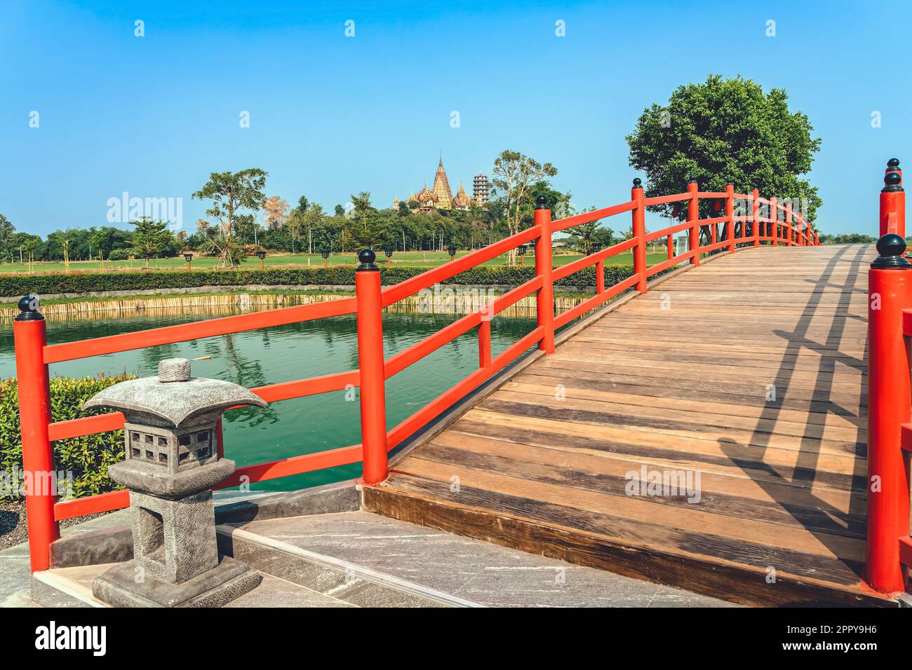 Magnifique vue sur le pont en bois rouge de style japonais au-dessus de l'étang d'émeraude avec des fontaines contre la nature du rizières en plein air. Jardin de style japonais avec Banque D'Images