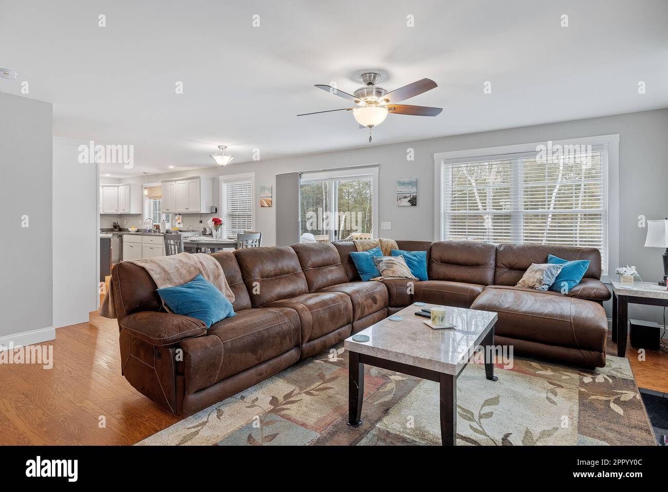 Ce salon moderne est doté d''un grand canapé en cuir marron et d''un parquet. Banque D'Images