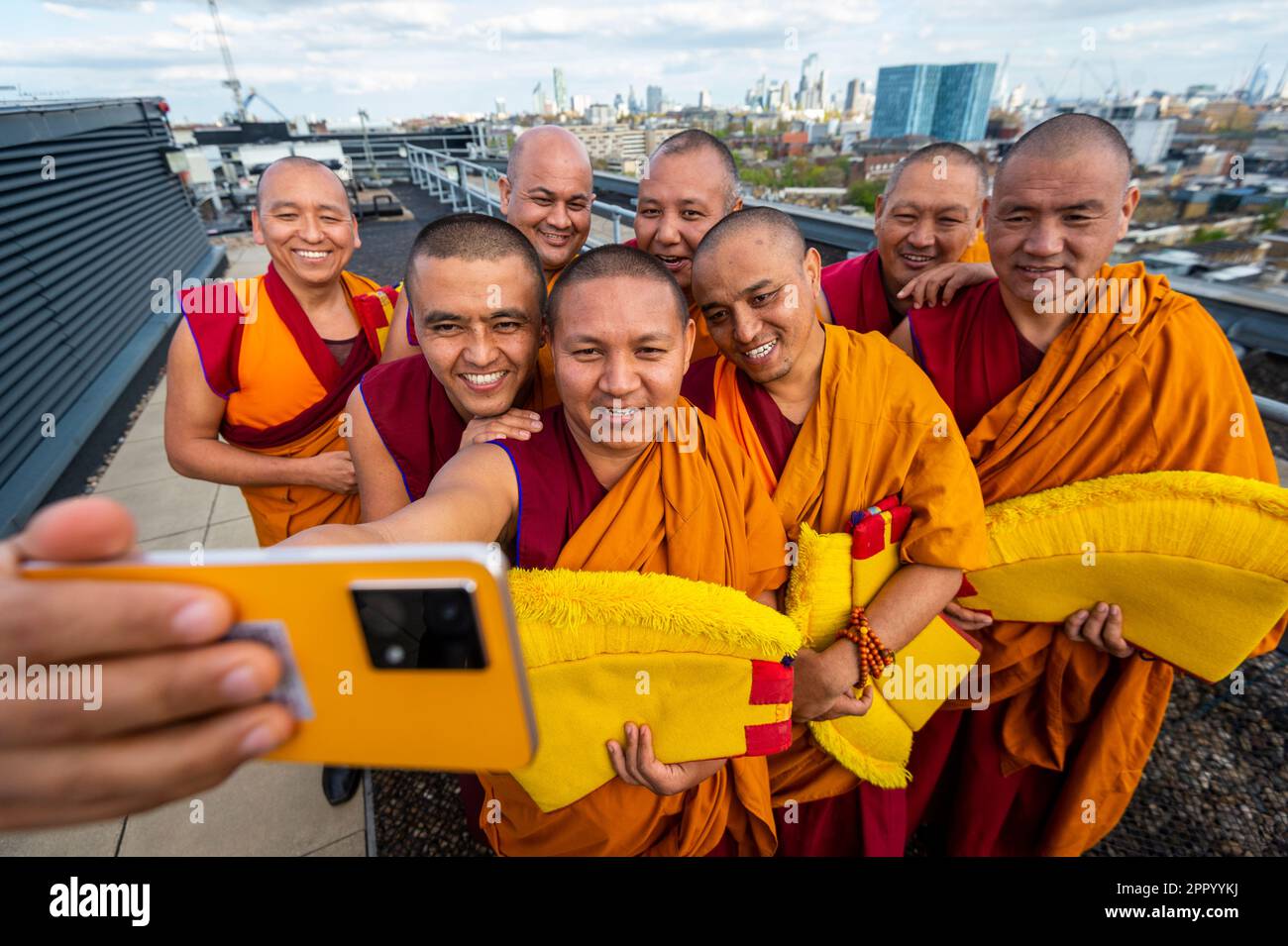 Londres, Royaume-Uni. 25 avril 2023. Les moines bouddhistes tibétains du Monastère Tashi Lhunpo prennent un selfie après avoir effectué une cérémonie à Kings place près de la Croix du Roi, en prévision du festival Songlines Encounters, le 24 mai. Fondé par le premier Dalaï Lama en 1447 à Shigatse, au Tibet central, Tashi Lhunpo est l'un des monastères les plus importants de la tradition bouddhiste tibétaine et est maintenant rétabli en exil en Inde. Credit: Stephen Chung / EMPICS / Alamy Live News Banque D'Images