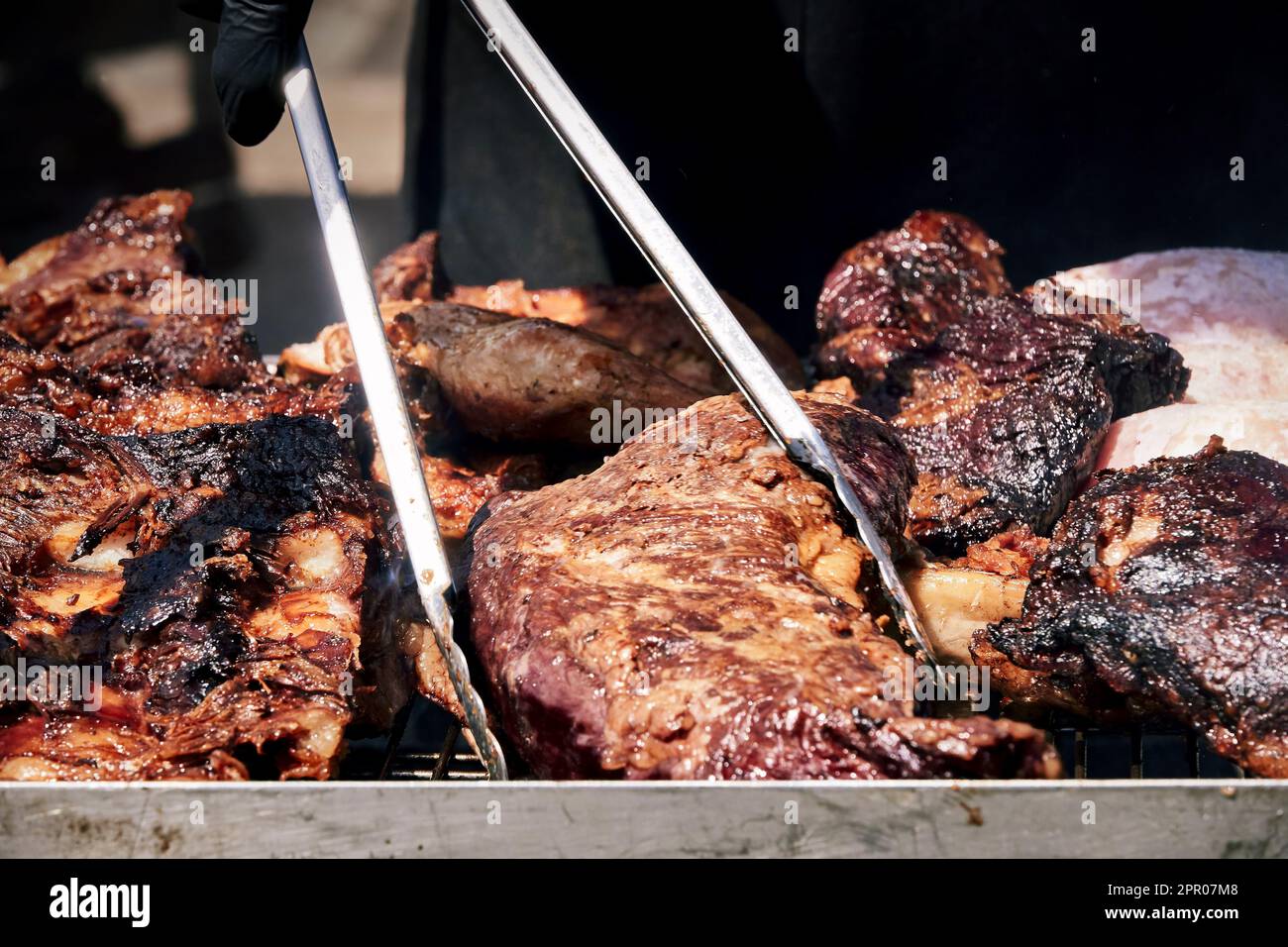 spiedini di carne sfrigolano sulla brace fumante, emanando un arome delizioso. Il calore del fuoco li rende succulenti e teneri Banque D'Images