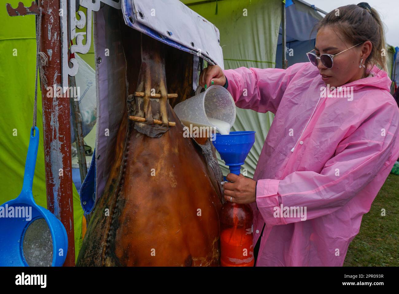 Bolorchimeg Batbayar bouteilles de lait fermenté de jument, connu sous le nom d'airag ou kumis, lors d'un festival d'airag au lac Urmiin Tsagaan Nuur, province de Bulgan, Mongolie sur 13 août 2022. Bolorchimeg, qui participe régulièrement au festival annuel, déclare : « Je suis fier de moi-même lorsque les gens louent qu’il est bien fermenté. » (Khorloo Khukhnohoi/Global Press Journal) Banque D'Images