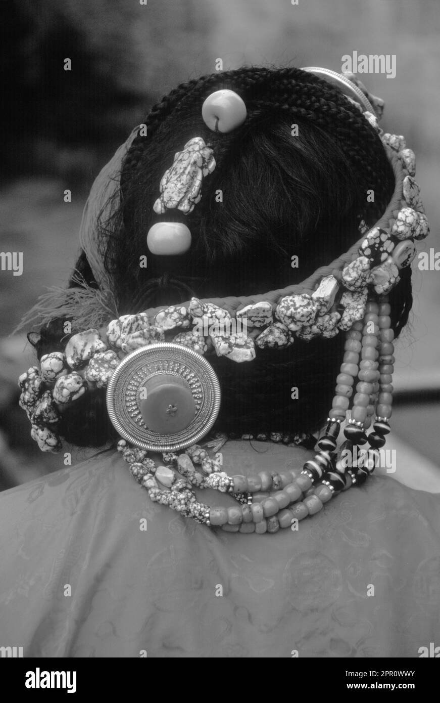 TURQUOISE, CORAIL et OR décorent les cheveux de cette FEMME TIBÉTAINE - LHASSA, TIBET Banque D'Images