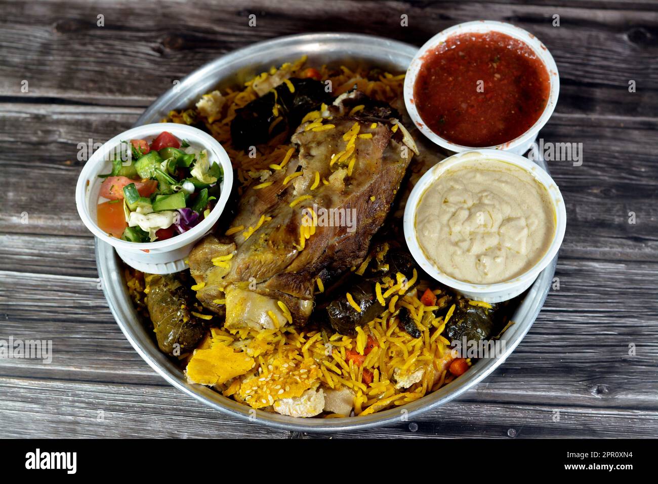 Une jarret d'agneau bien cuit avec du riz Basmati jaune et des légumes mélangés et des feuilles de raisin farcies mahshi Mahshy avec du riz blanc cuit rôti dans la ov Banque D'Images