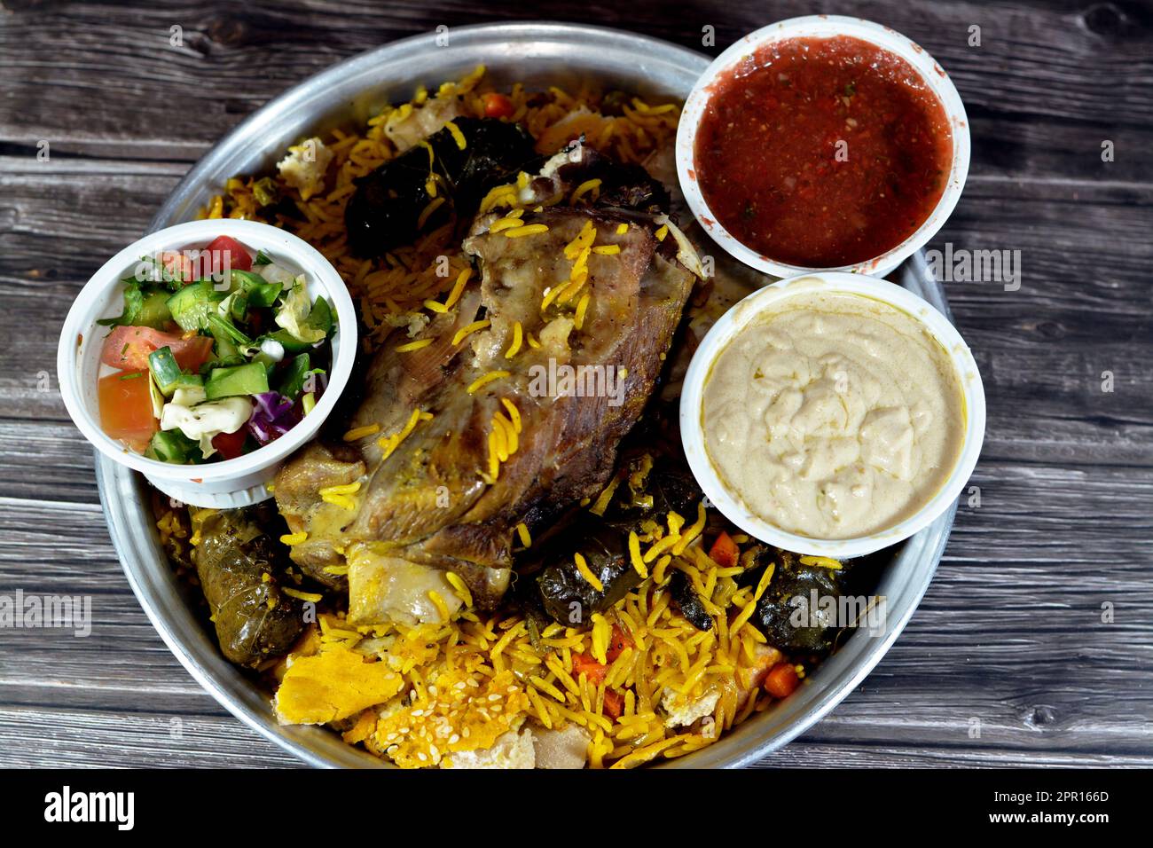 Une jarret d'agneau bien cuit avec du riz Basmati jaune et des légumes mélangés et des feuilles de raisin farcies mahshi Mahshy avec du riz blanc cuit rôti dans la ov Banque D'Images