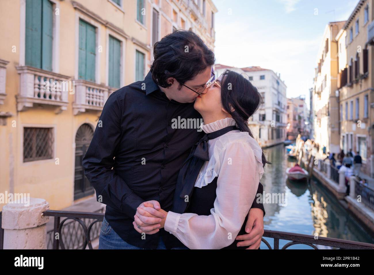 Un couple mixte d'amoureux embrassant à Venise, moment passionné Banque D'Images