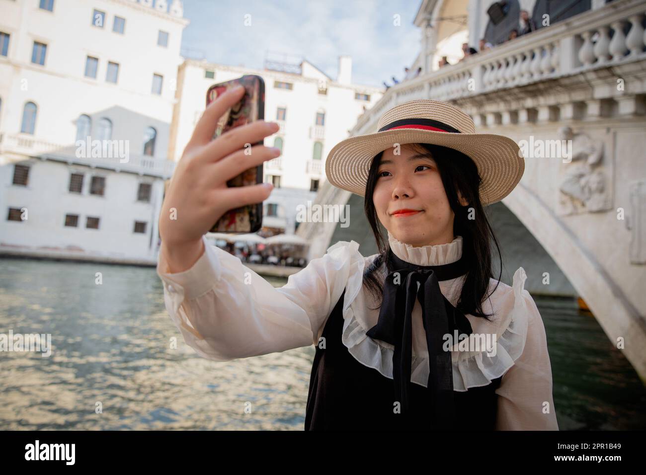 Un touriste chinois prend un selfie en face du pont du Rialto à Venise Banque D'Images
