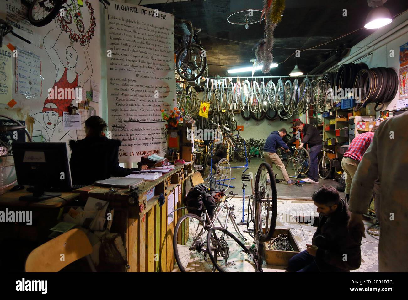 Personnes travaillant sur des bicyclettes à la Cyclofficines, 15 rue Pierre Bonnard, une coopérative de vélos à bas prix et en réparation dans l'arr 20E, Paris, France. Banque D'Images