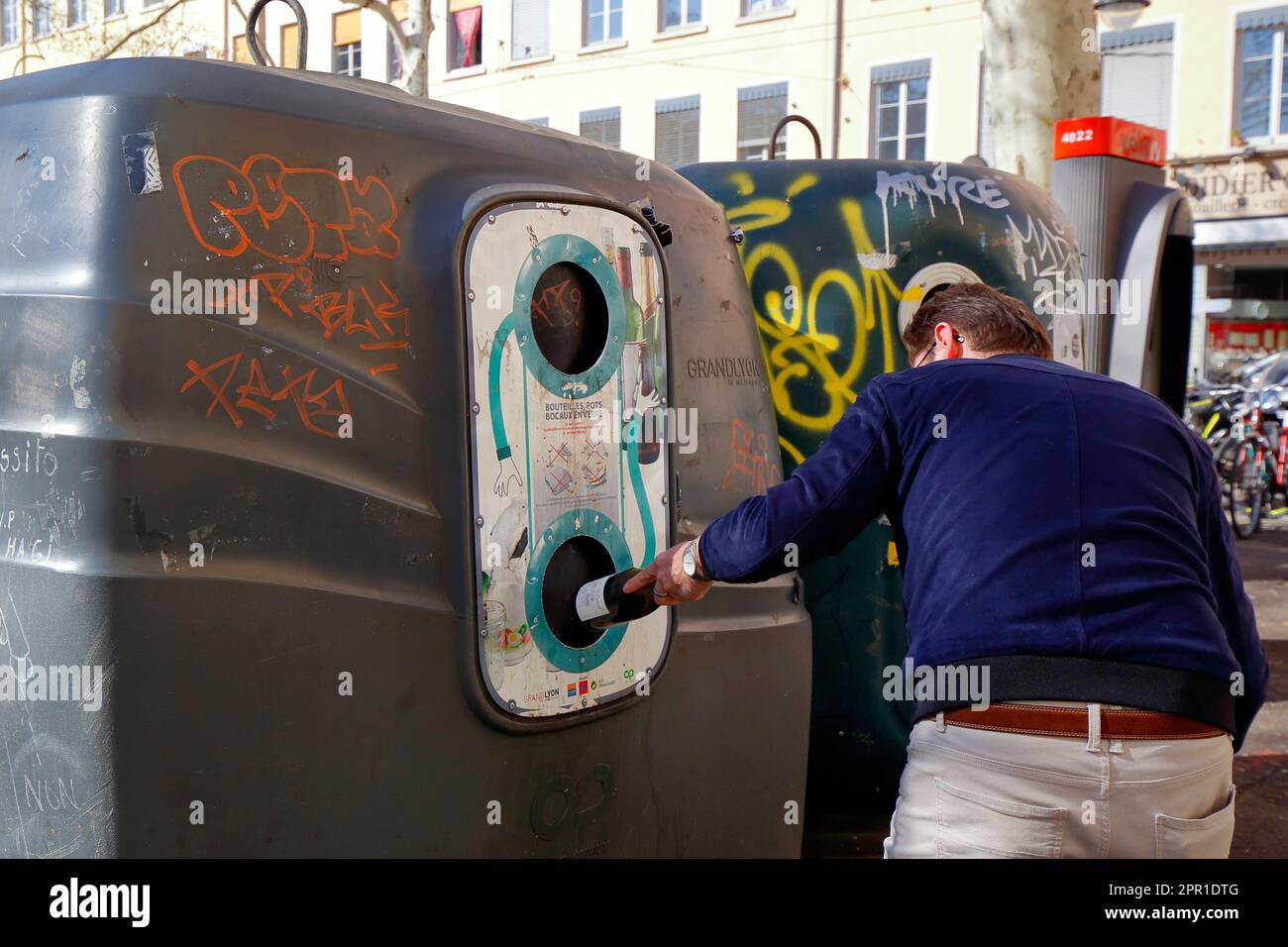 Une personne dépose une bouteille de vin vide dans un grand bac de recyclage  municipal pour bouteilles de verre à Lyon, France Photo Stock - Alamy