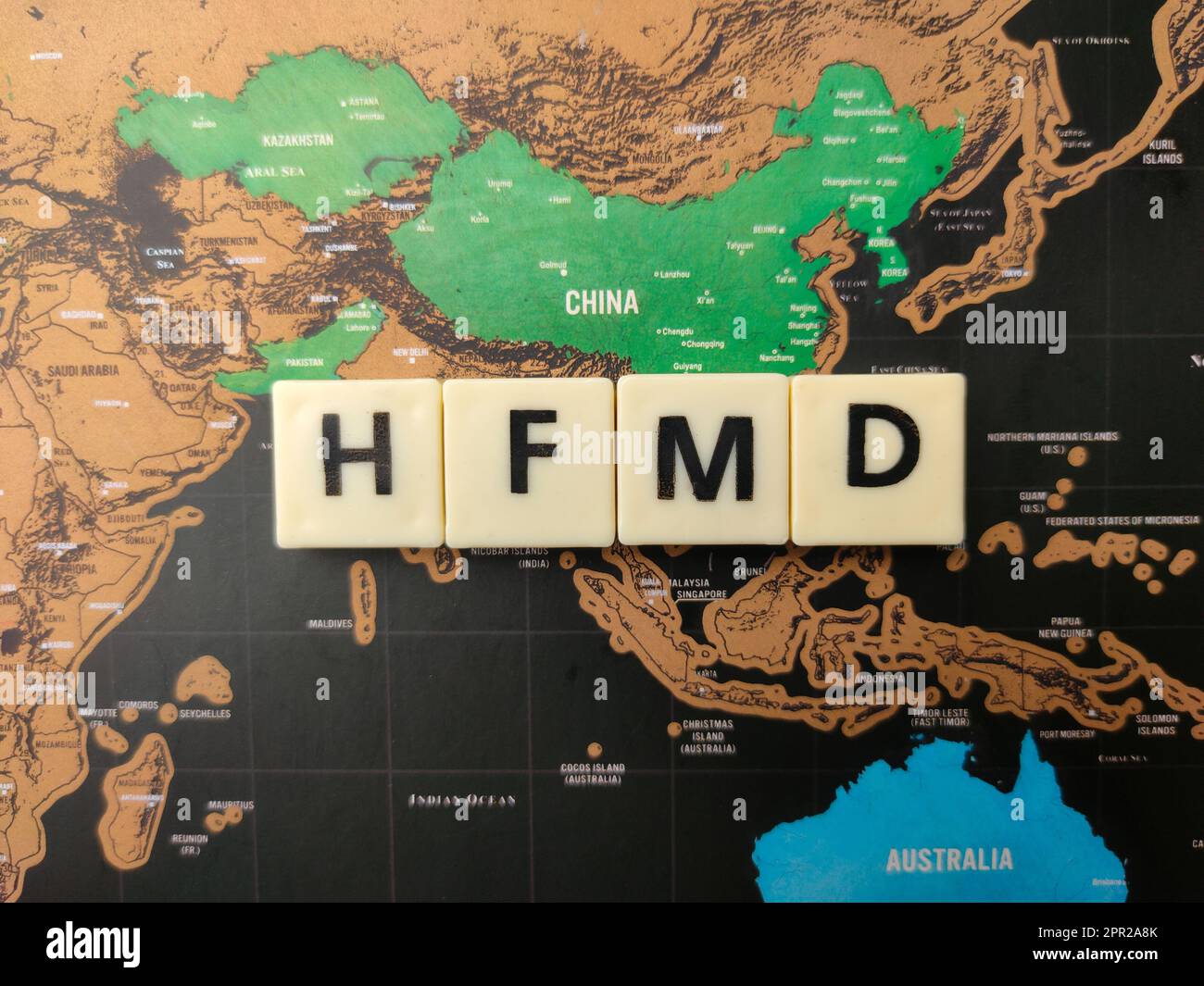 Vue de dessus jouets mot avec le mot HFMD sur un fond de carte du monde. Banque D'Images