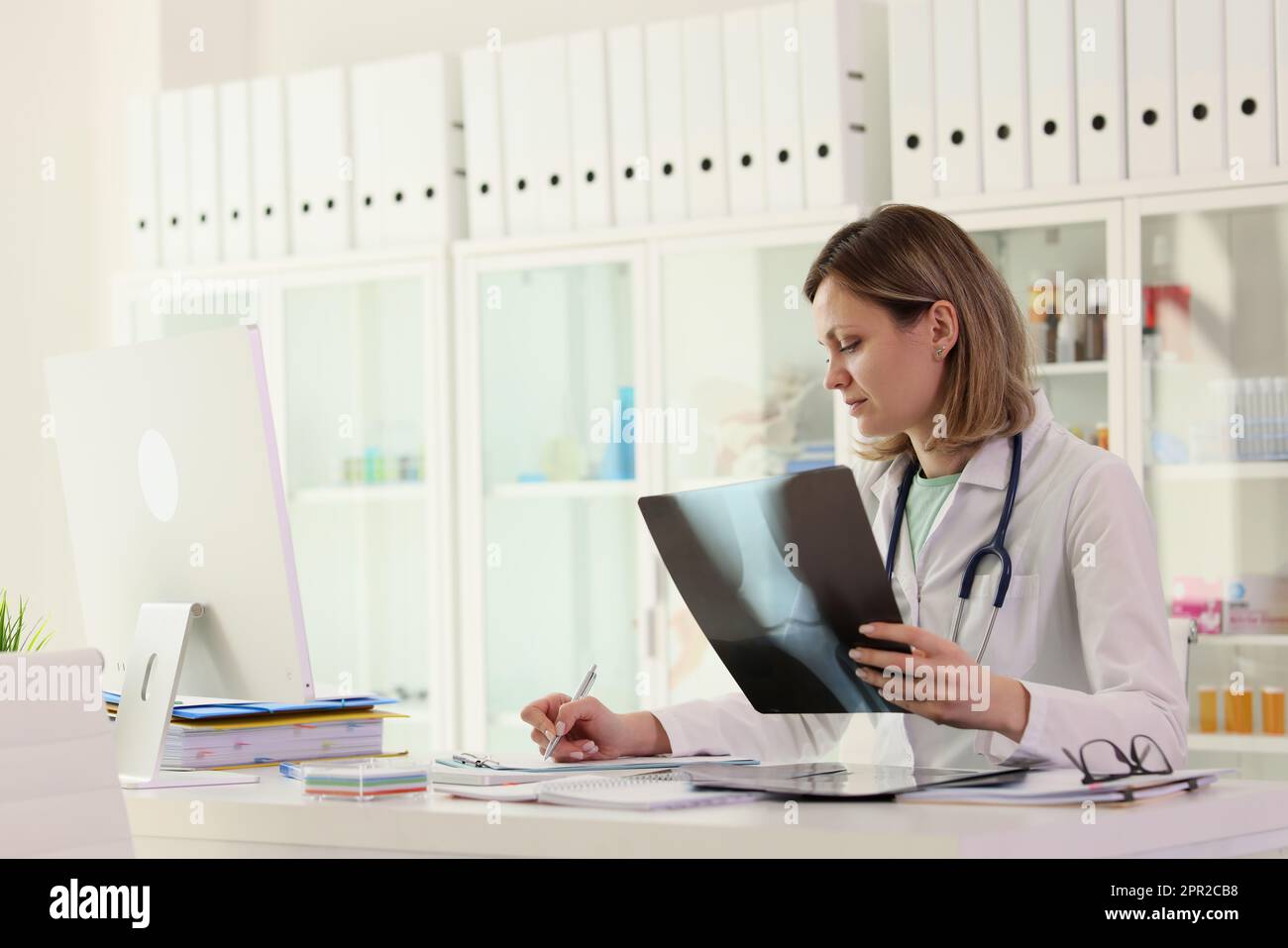 Un médecin spécialisé examine la radiographie des notes de prise de joint du patient Banque D'Images