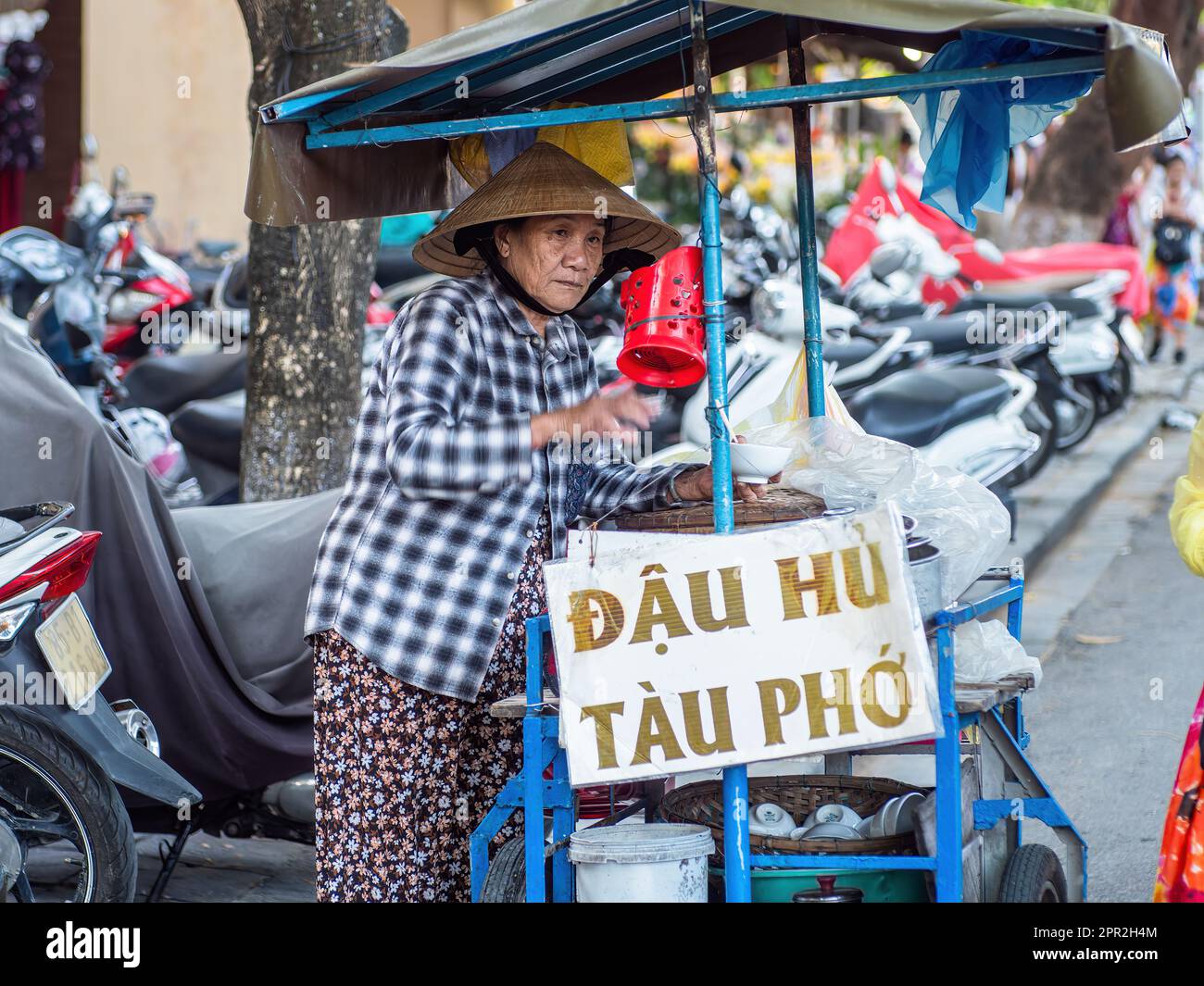 Vieille dame qui vend des nouilles à Hoi an, province de Quang Nam, Vietnam. La vieille ville de Hoi an est un site classé au patrimoine mondial, et célèbre pour son bu bien conservé Banque D'Images