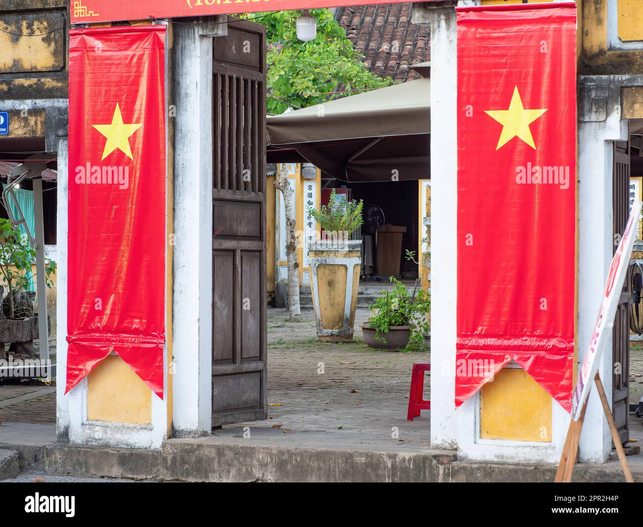 Porte à une ancienne maison traditionnelle à Hoi an, province de Quang Nam, Vietnam, décorée de bannières vietnamiennes. La vieille ville de Hoi an est classée au patrimoine mondial Banque D'Images