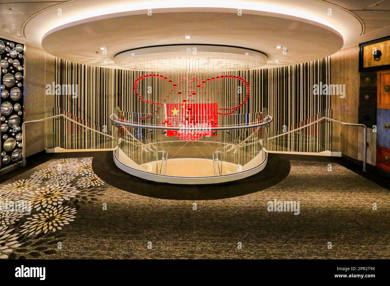 Drapeau national chinois dans les escaliers du navire de croisière américain Quantum of the Seas, navires Royal Caribbean RCCL, croisières en mer de Chine, lustre de perles de verre Banque D'Images