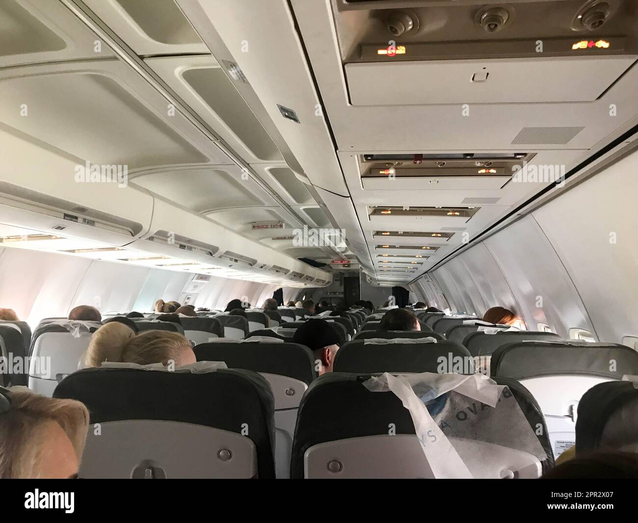 Les touristes dans la cabine d'un avion affrété volant avec des sièges volent pour se reposer dans les pays exotiques chauds tropicaux, une station balnéaire. Banque D'Images