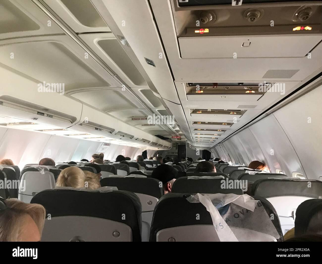 Les touristes dans la cabine d'un avion affrété volant avec des sièges volent pour se reposer dans les pays exotiques chauds tropicaux, une station balnéaire. Banque D'Images