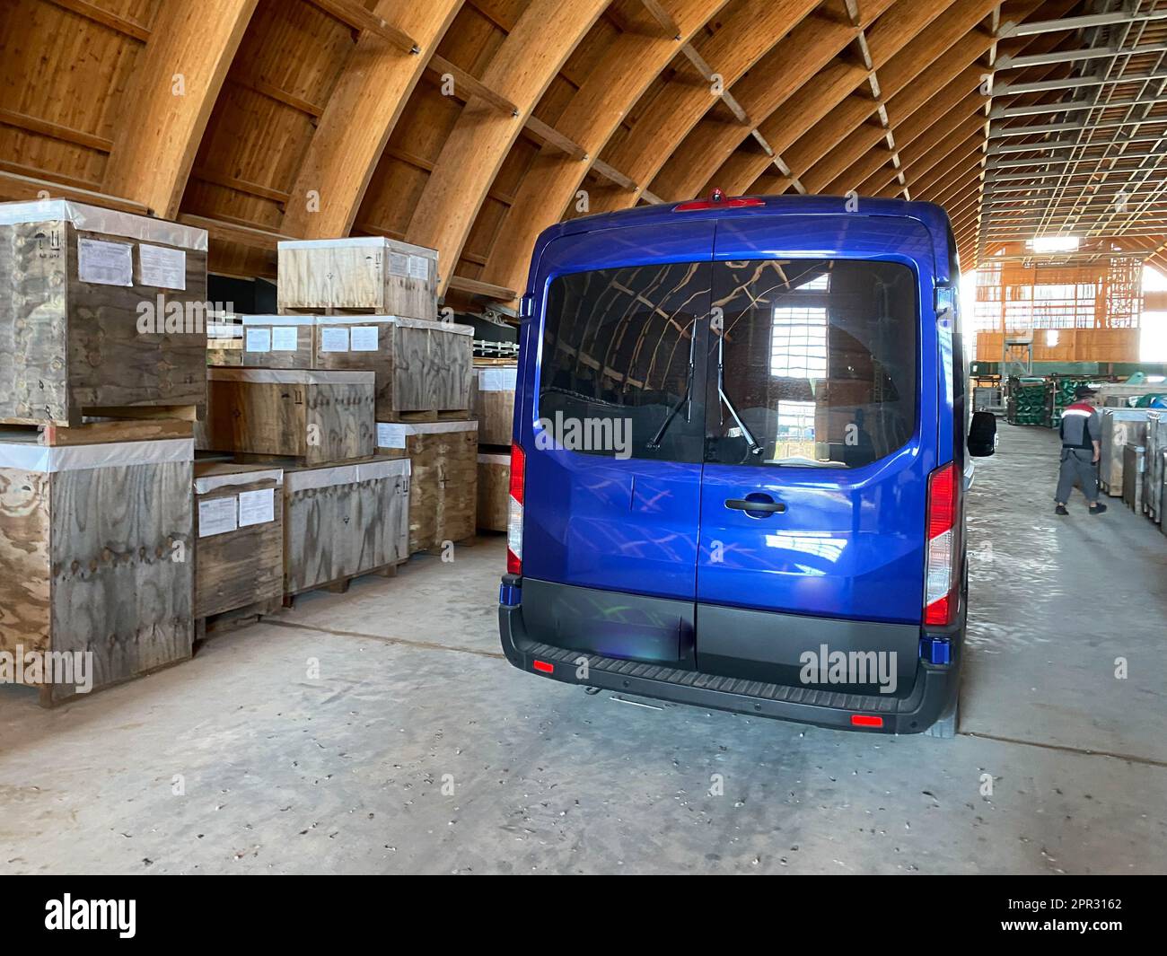 Un minibus bleu dans un entrepôt pour l'équipement et les matériaux industriels. Concept : livraison, logistique, incoterms dap, conditions de livraison dpp. Banque D'Images
