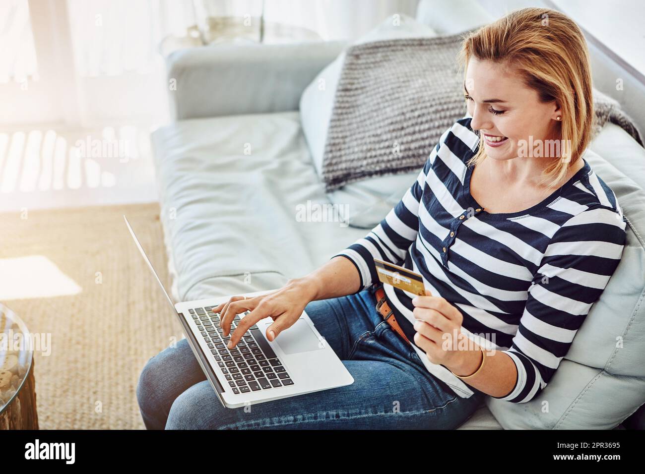 Détendez-vous sur le canapé et dépensez un peu d'argent. Prise de vue en grand angle d'une jeune femme attrayante magasiner en ligne depuis le confort de la maison. Banque D'Images