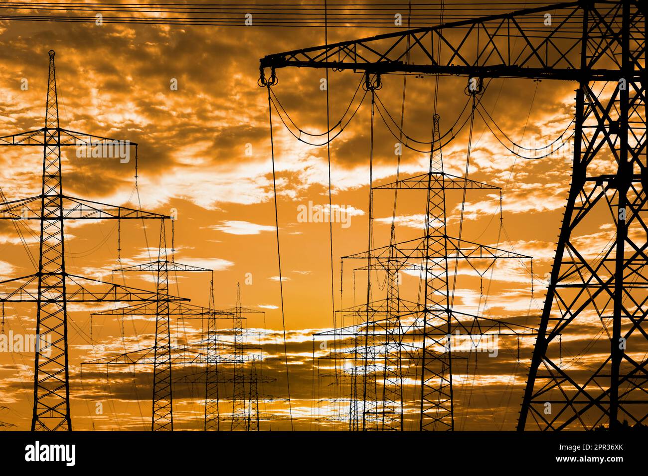 pylônes électriques haute tension contre le ciel avec des nuages spectaculaires Banque D'Images