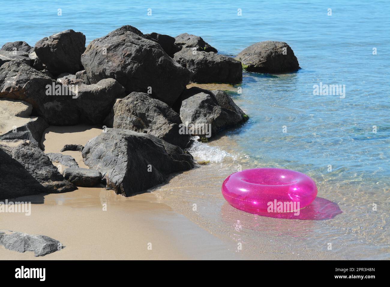 Anneau gonflable lumineux sur la plage de sable près de la mer Banque D'Images