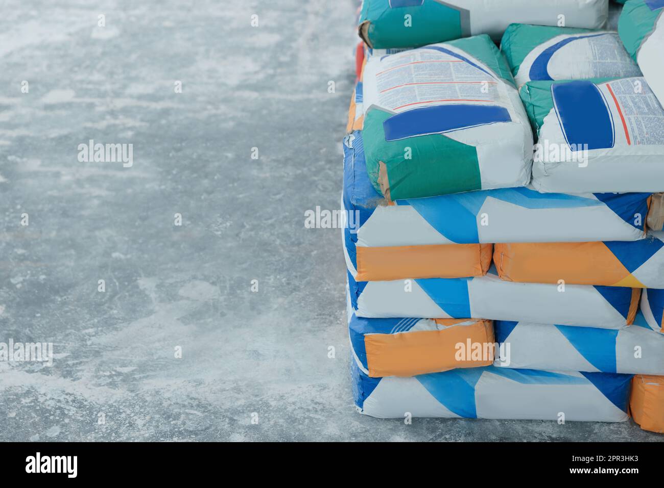 Sacs avec poudre de ciment sur sol en pierre, espace pour le texte Banque D'Images