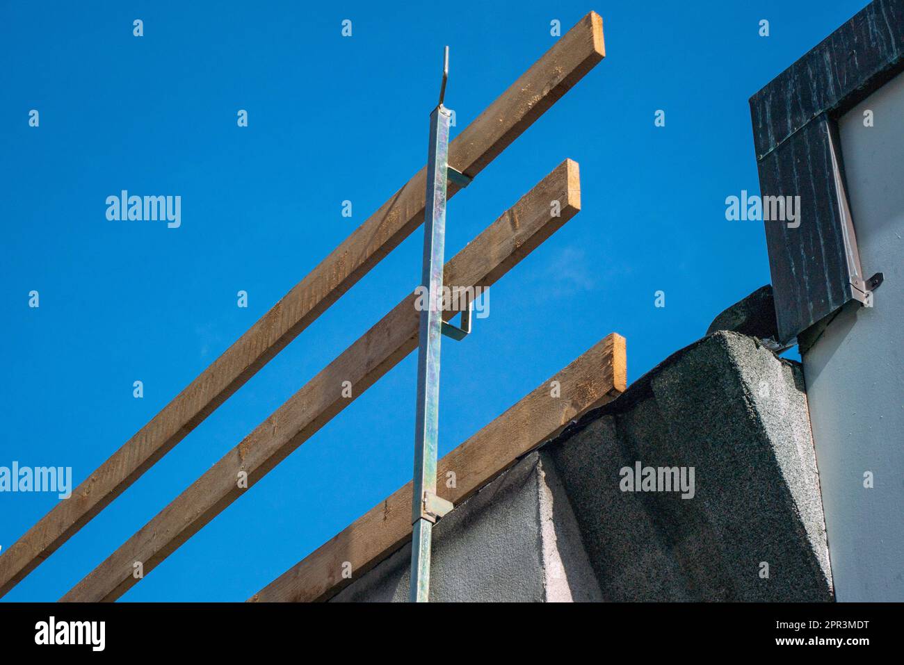 échafaudage antichute sur un chantier de construction. toit avec rambardes en bois sur le bord du toit accroché aux avant-toits du toit du bâtiment. Banque D'Images