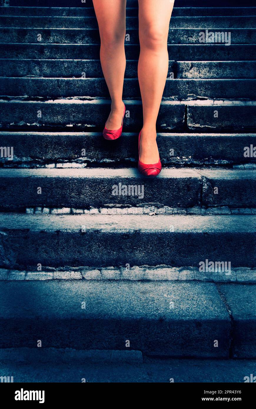 une femme porte des chaussures rouges et descend un escalier Banque D'Images