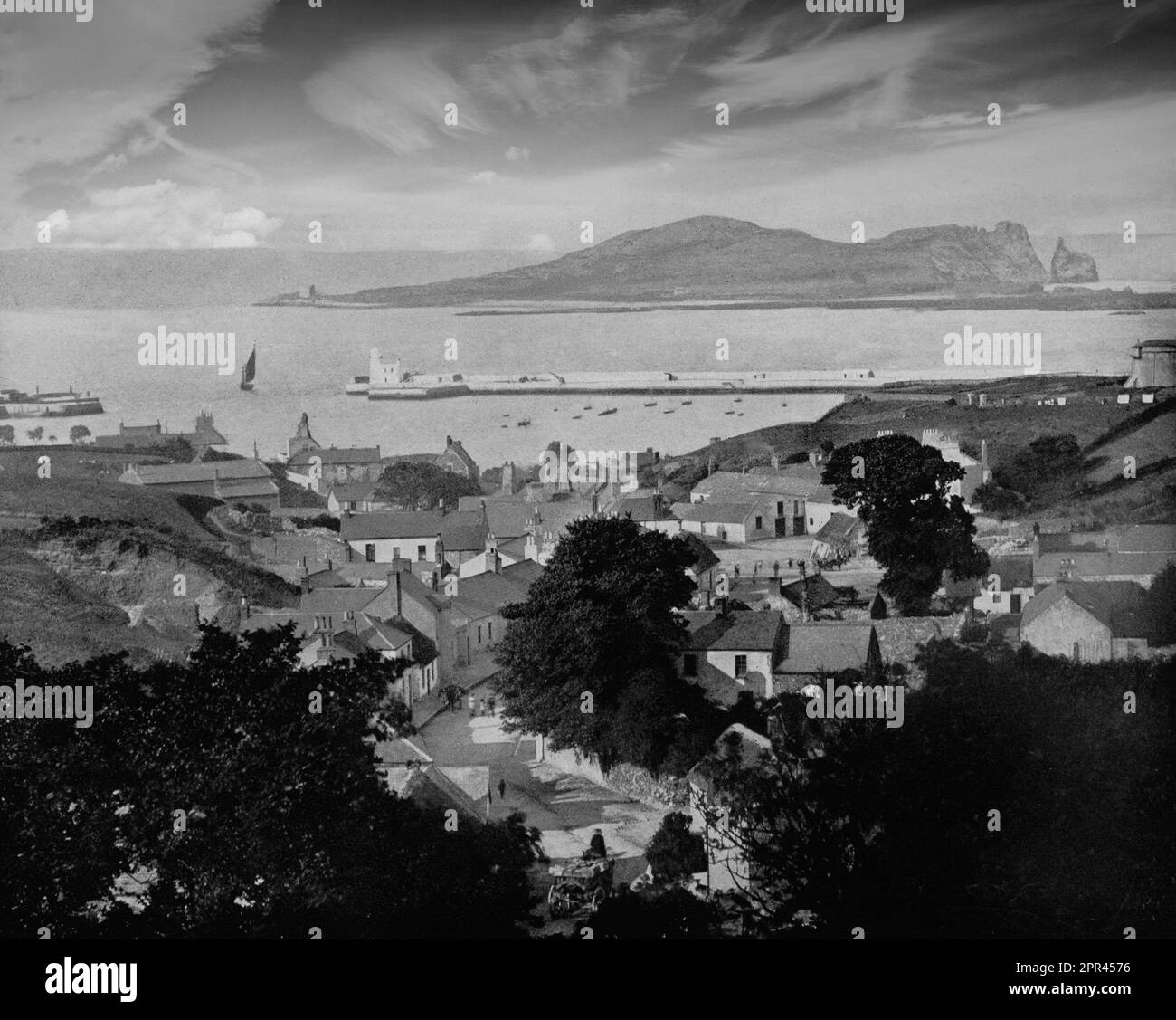 Une vue de la fin du 19th siècle sur Howth, un village péninsulaire et maintenant une banlieue extérieure de Dublin, Irlande. La péninsule de Howth Head, forme la limite nord de la baie de Dublin, et inclut l'île de Ireland's Eye. Un village de pêcheurs et un petit port de commerce depuis au moins le 14th siècle, Howth a été choisi comme lieu pour le port du paquet de courrier (service postal) navire au début du 19th siècle, dont la construction a commencé en 1807. Banque D'Images