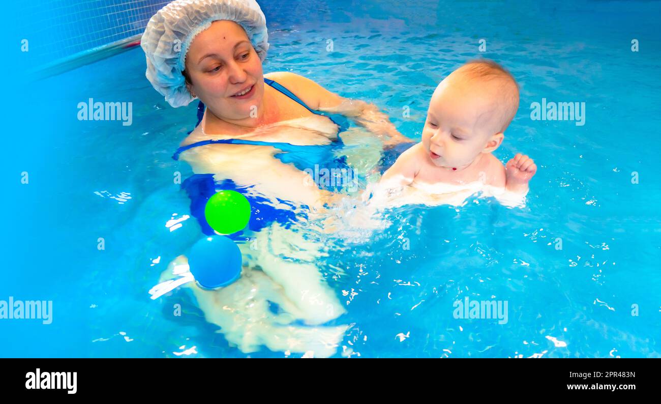 Adorable petite fille appréciant nager dans une piscine avec sa mère cours de développement