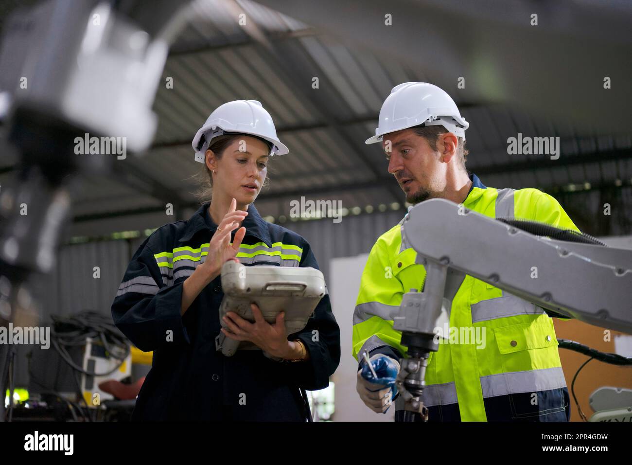 Un ingénieur travaille à l'usine de bras robotisés. Concept de technologie et d'ingénierie. Banque D'Images