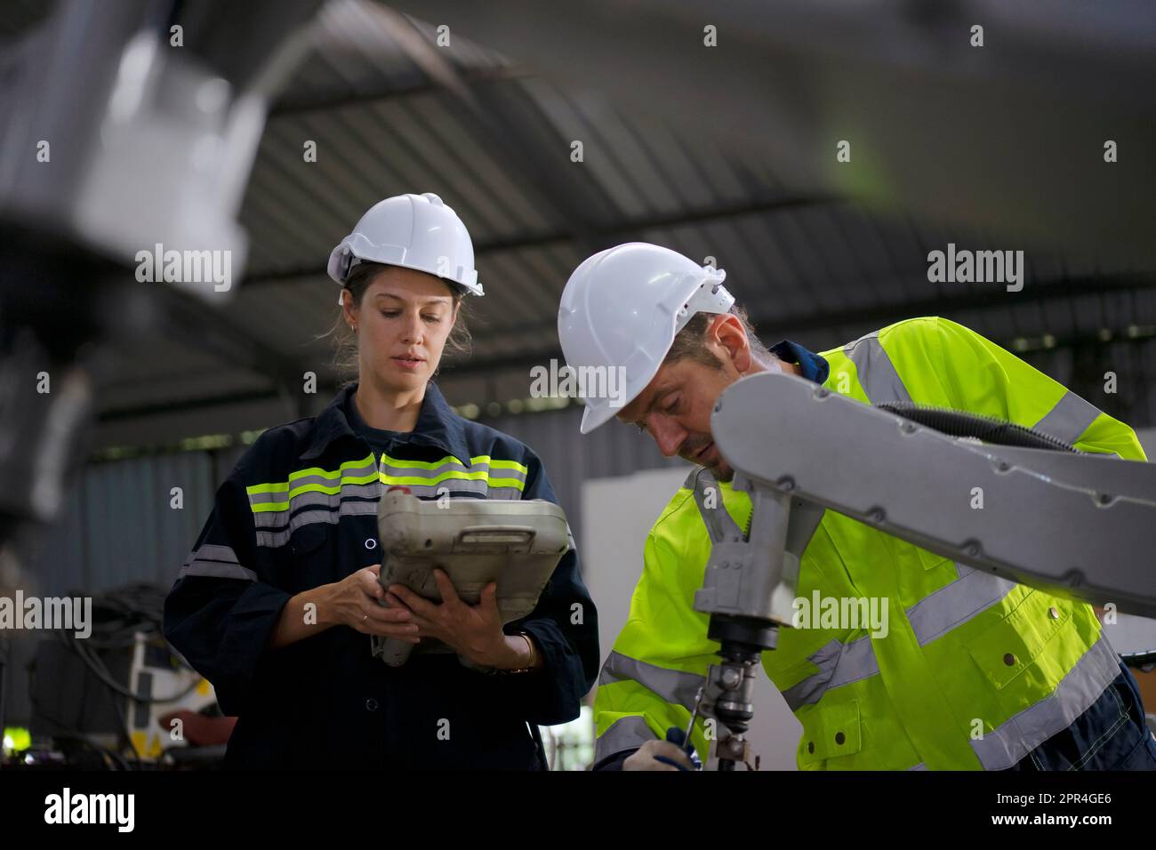 Un ingénieur travaille à l'usine de bras robotisés. Concept de technologie et d'ingénierie. Banque D'Images