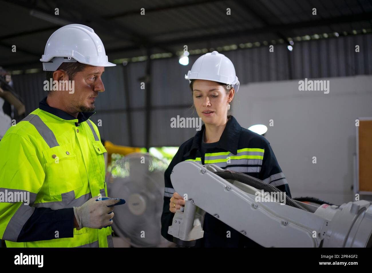 Un ingénieur travaille à l'usine de bras robotisés. Concept de technologie et d'ingénierie. Banque D'Images