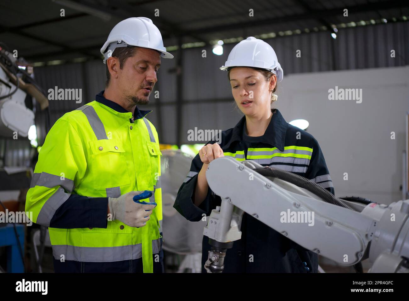 Un ingénieur travaille à l'usine de bras robotisés. Concept de technologie et d'ingénierie. Banque D'Images