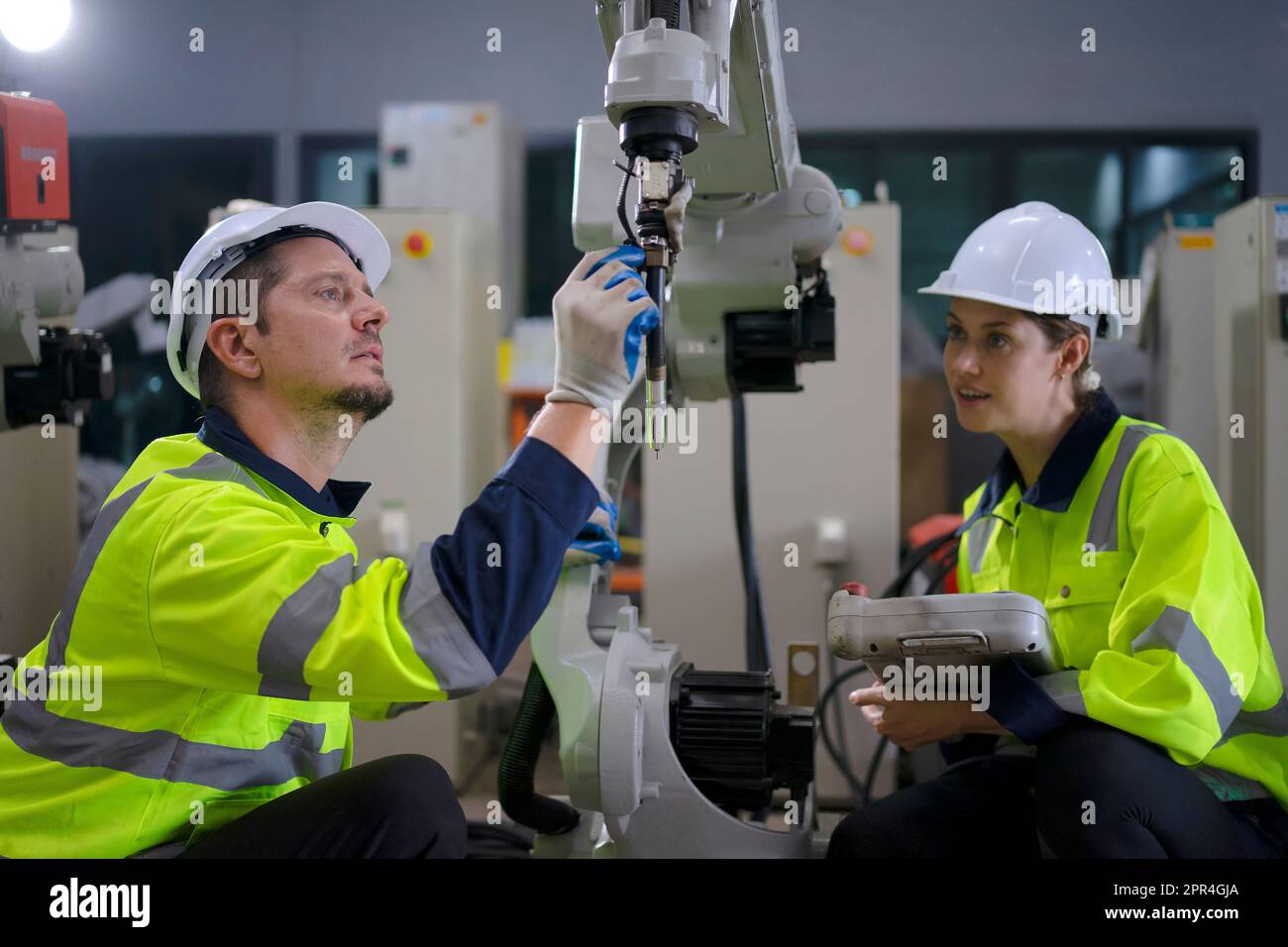 Un ingénieur travaille à l'usine de bras robotisés. Concept de technologie et d'ingénierie. Banque D'Images