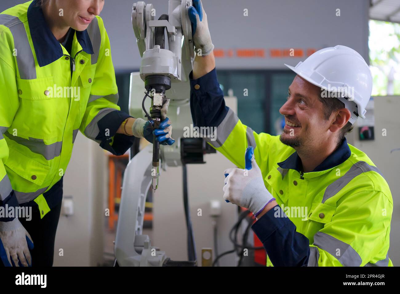 Un ingénieur travaille à l'usine de bras robotisés. Concept de technologie et d'ingénierie. Banque D'Images
