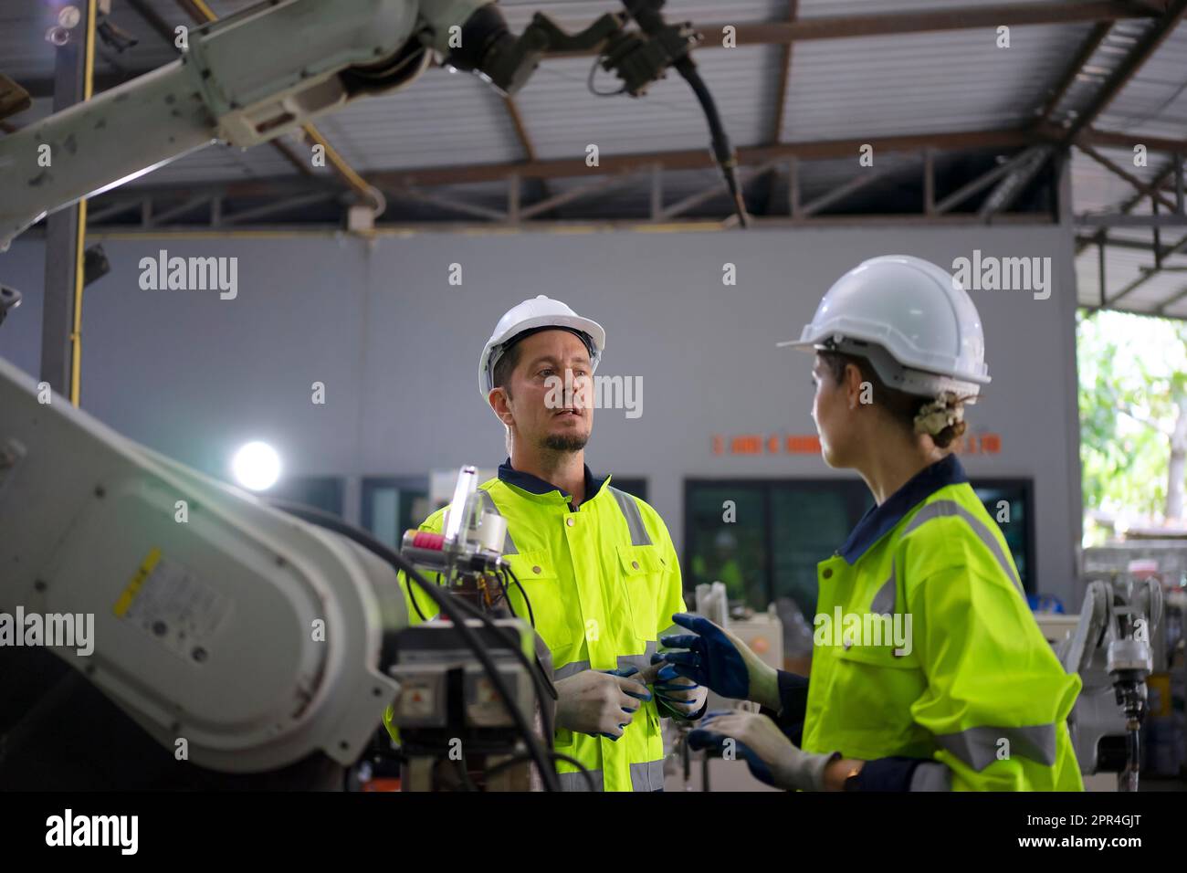 Un ingénieur travaille à l'usine de bras robotisés. Concept de technologie et d'ingénierie. Banque D'Images