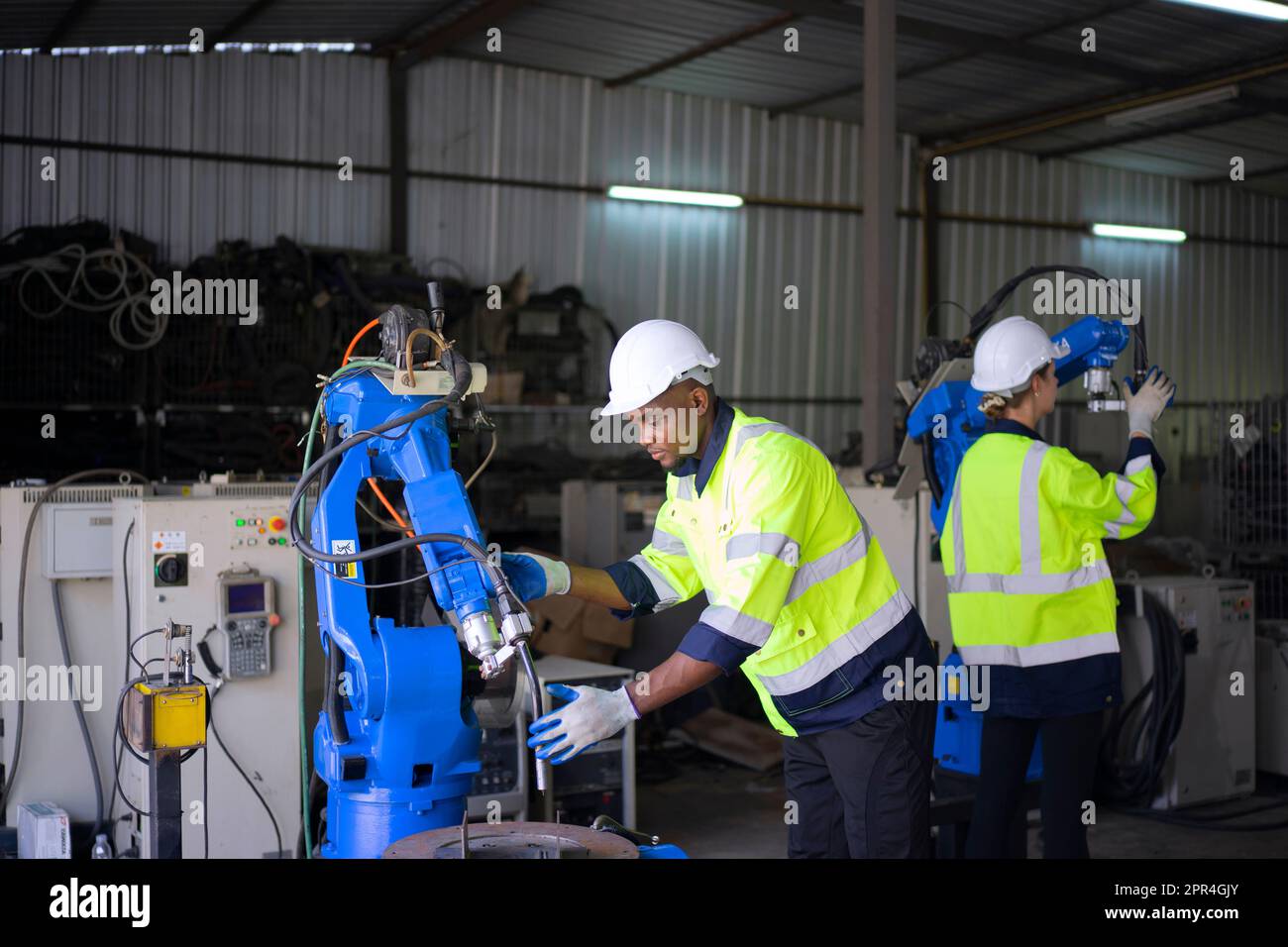 Un ingénieur travaille à l'usine de bras robotisés. Concept de technologie et d'ingénierie. Banque D'Images