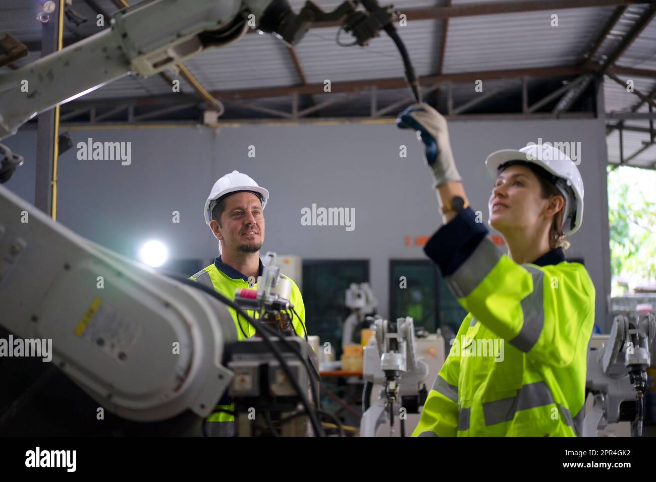 Un ingénieur travaille à l'usine de bras robotisés. Concept de technologie et d'ingénierie. Banque D'Images
