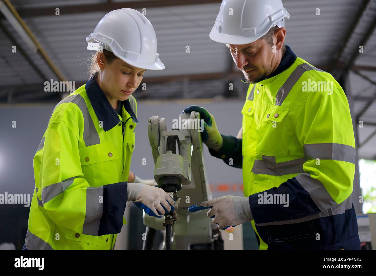 Un ingénieur travaille à l'usine de bras robotisés. Concept de technologie et d'ingénierie. Banque D'Images