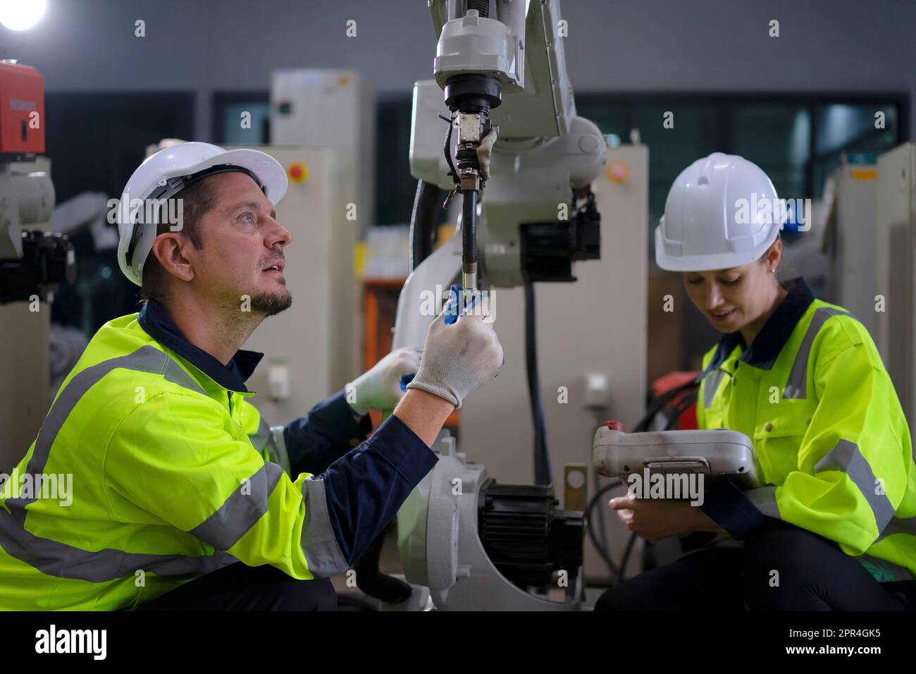 Un ingénieur travaille à l'usine de bras robotisés. Concept de technologie et d'ingénierie. Banque D'Images