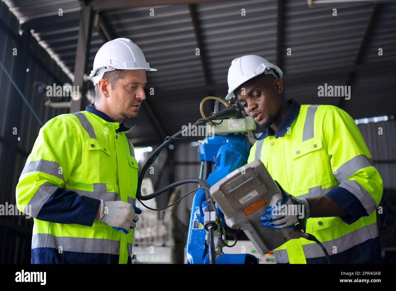 Un ingénieur travaille à l'usine de bras robotisés. Concept de technologie et d'ingénierie. Banque D'Images