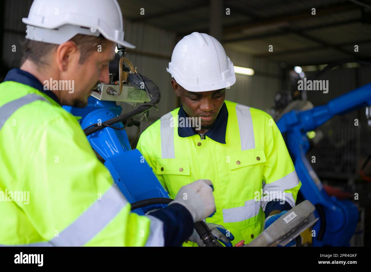 Un ingénieur travaille à l'usine de bras robotisés. Concept de technologie et d'ingénierie. Banque D'Images