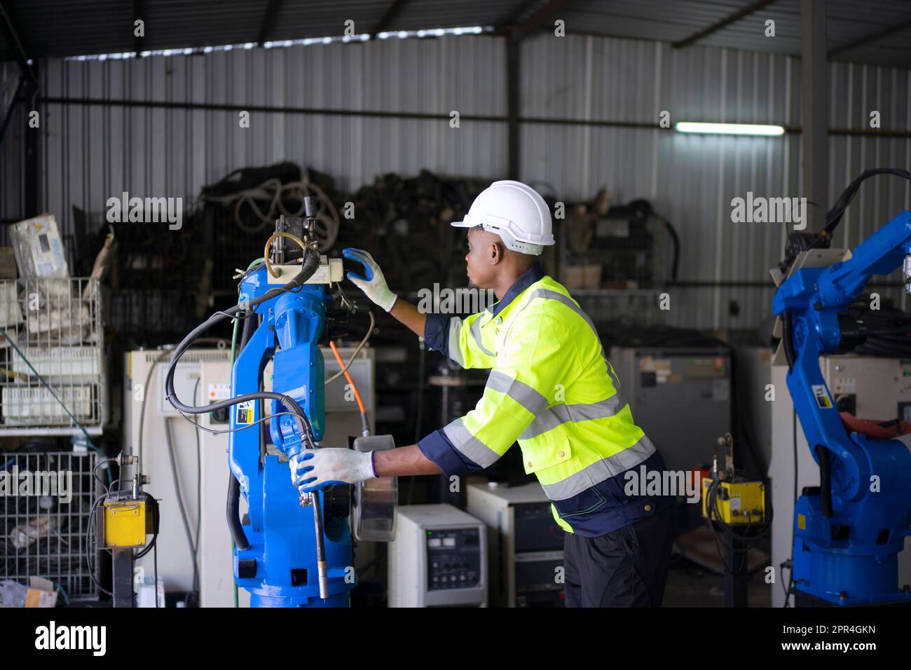 Un ingénieur travaille à l'usine de bras robotisés. Concept de technologie et d'ingénierie. Banque D'Images