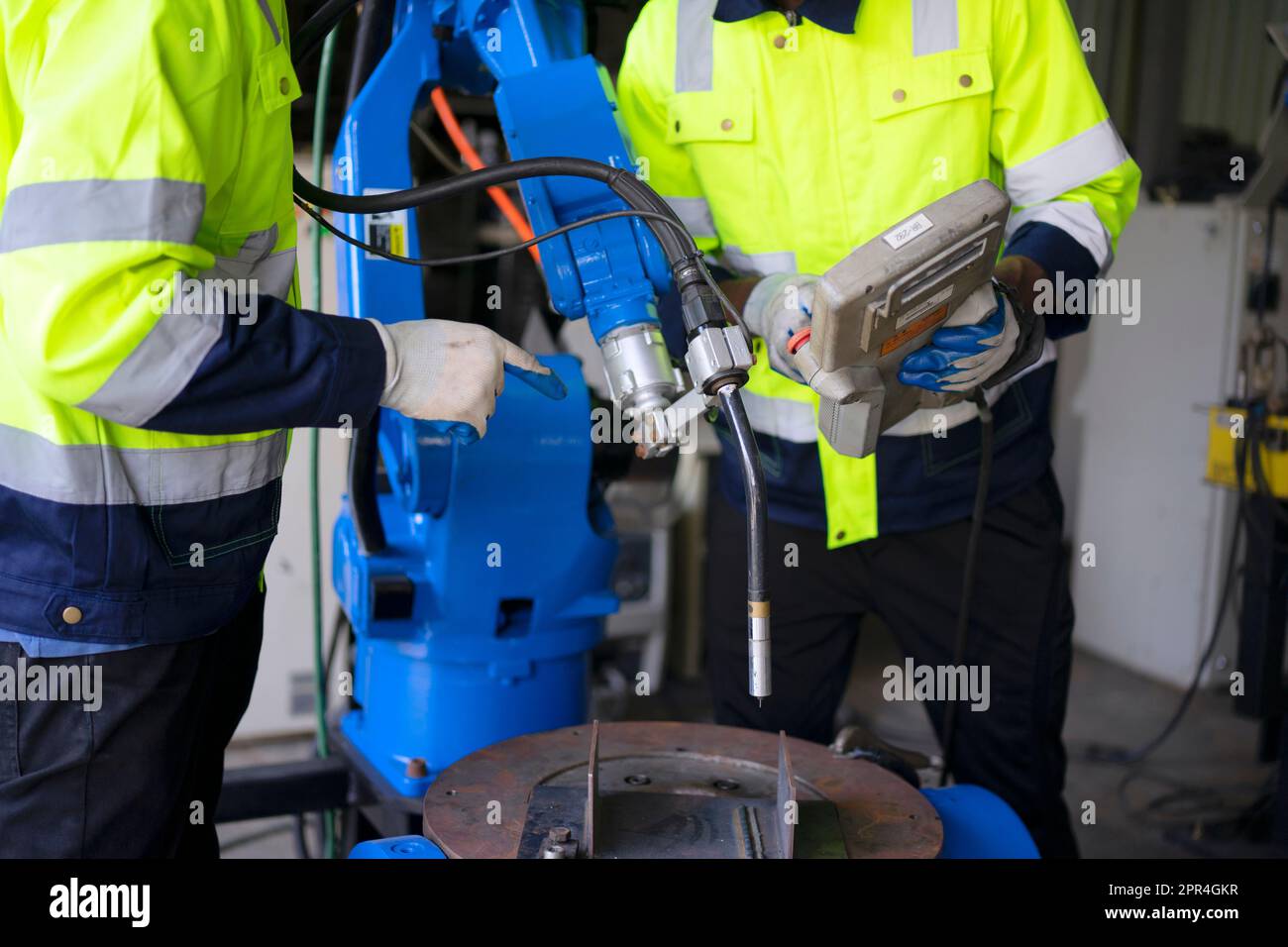 Un ingénieur travaille à l'usine de bras robotisés. Concept de technologie et d'ingénierie. Banque D'Images
