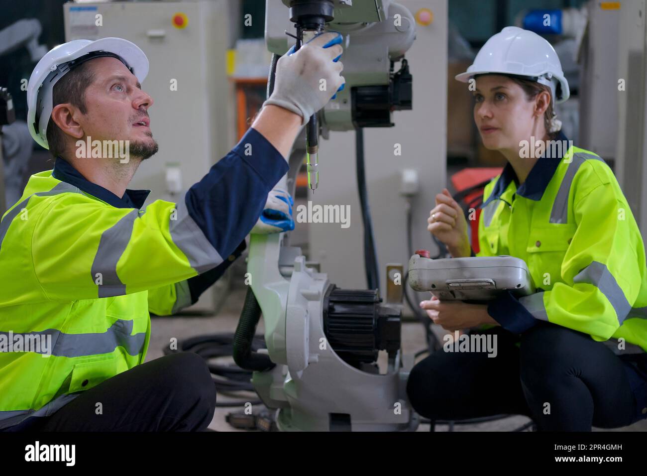 Un ingénieur travaille à l'usine de bras robotisés. Concept de technologie et d'ingénierie. Banque D'Images