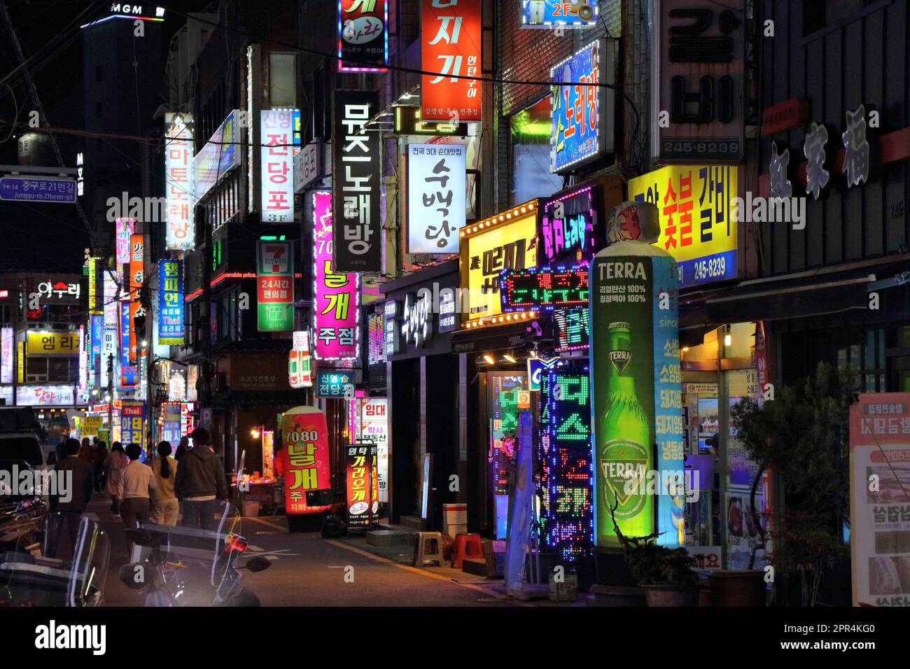 BUSAN, CORÉE DU SUD - 28 MARS 2023: Les gens visitent les rues de restaurant de nuit avec des néons dans le quartier de Jung-gu à Busan. Banque D'Images