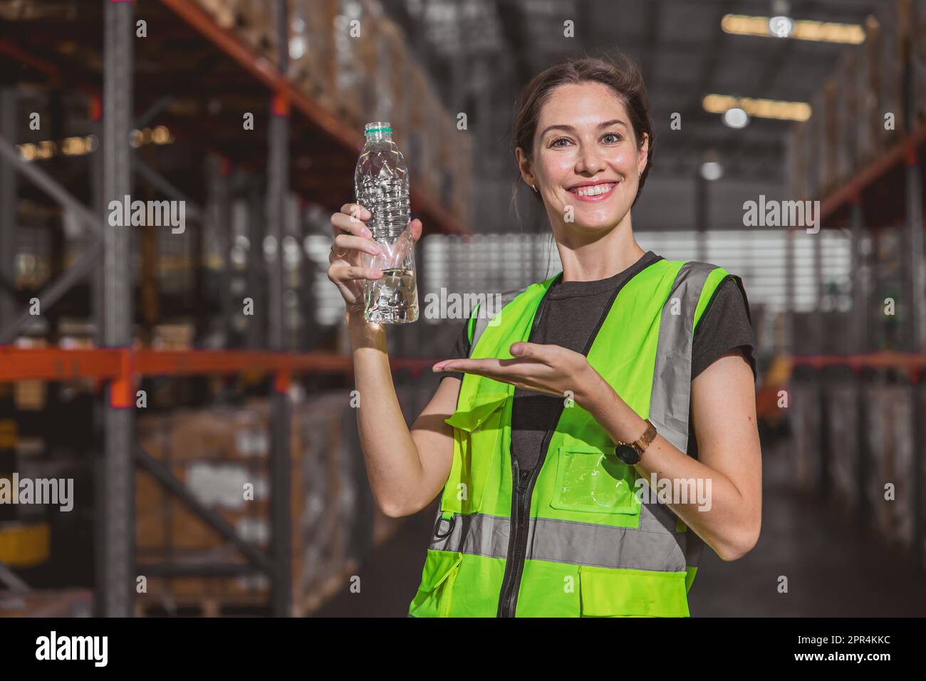 un travailleur heureux avec une bouteille d'eau potable présente buvez de l'eau propre pour un travail frais et sain dans un lieu de travail chaud Banque D'Images