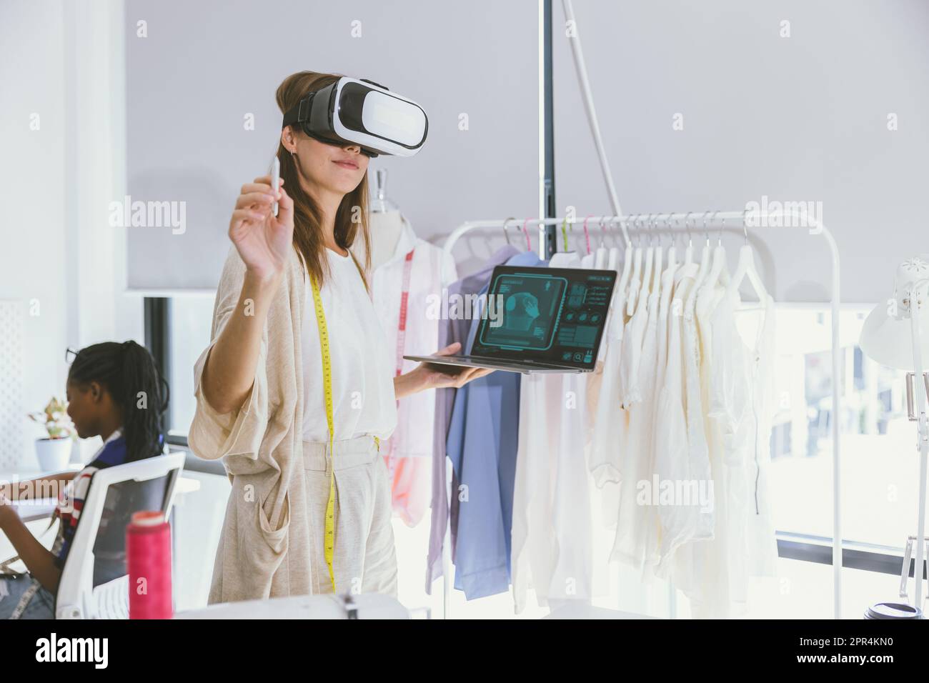 Concepteur de costumes utilisant la technologie moderne de conception numérique visuelle VR dans un studio sur mesure Banque D'Images