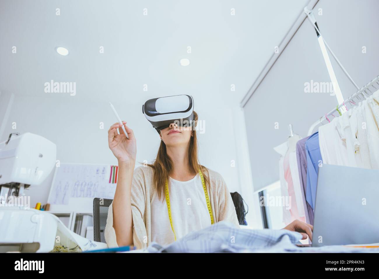 Concepteur de costumes utilisant la technologie moderne de conception numérique visuelle VR dans un studio sur mesure Banque D'Images
