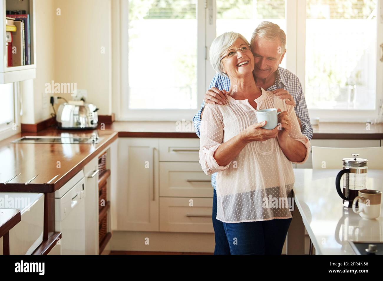 Faire un point de montrer qu'il l'a manquée. un couple senior affectueux dans la cuisine. Banque D'Images