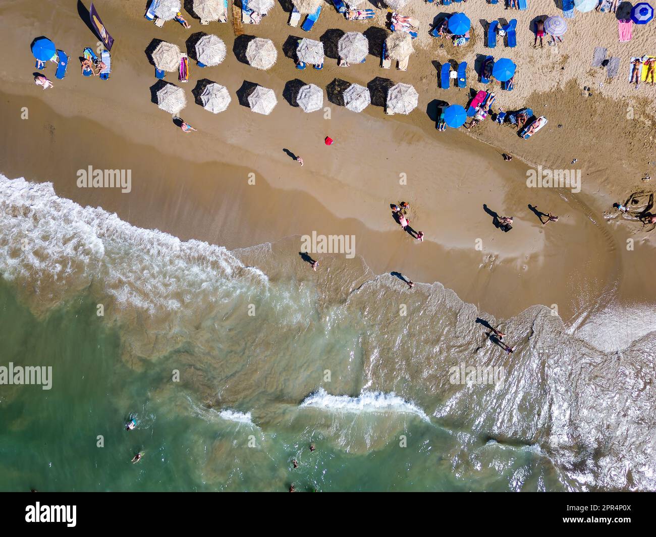 Vue aérienne de haut en bas d'une plage animée avec parasols (Nea Chora, Chania, Crète) Banque D'Images